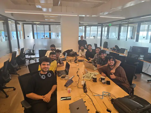 The team around the long desk, laptops open