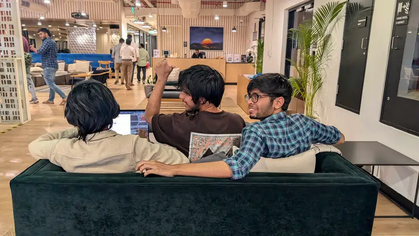 Three engineers on the lounge sofa with one laptop between them