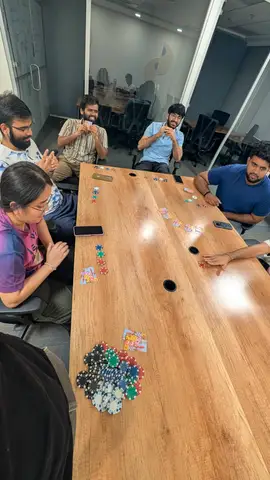 A hand of poker playing out on the boardroom table